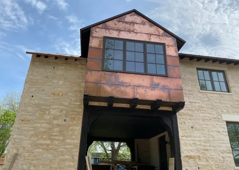 Copper metal panel facade on a stone building for Metal Roof Coating in Waunakee