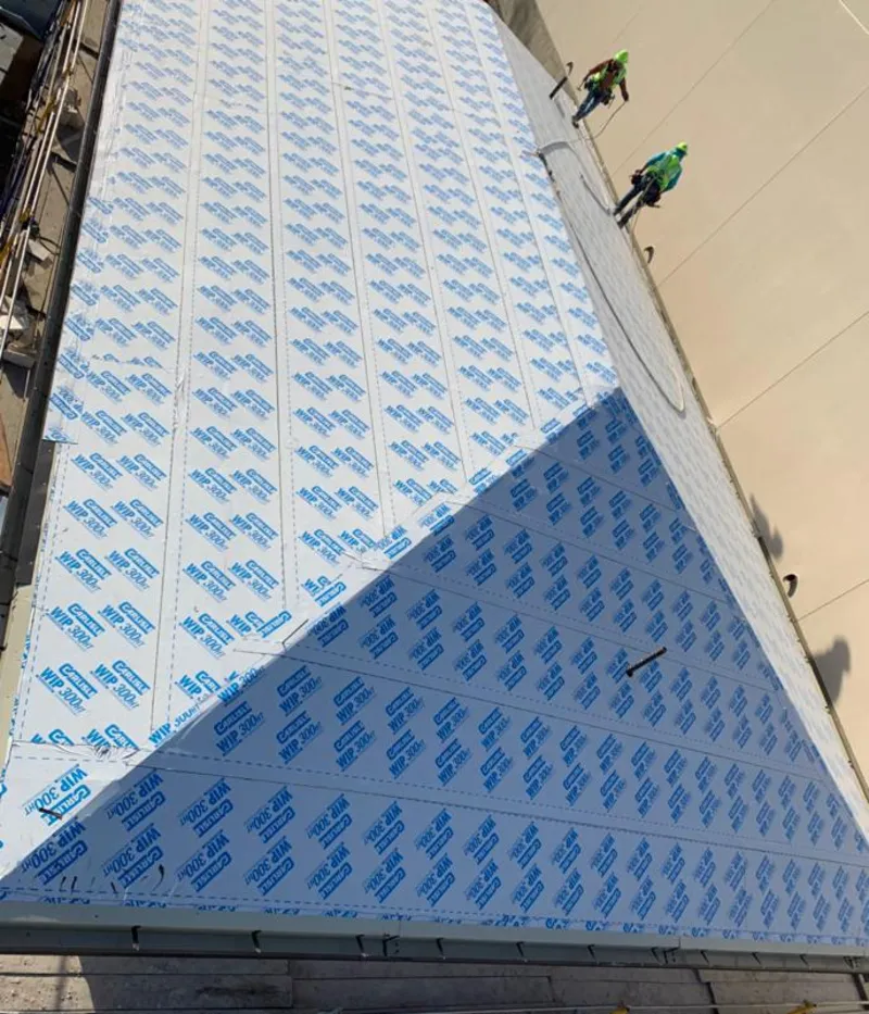 Professional roofers installing underlayment on a metal roof in Waunakee